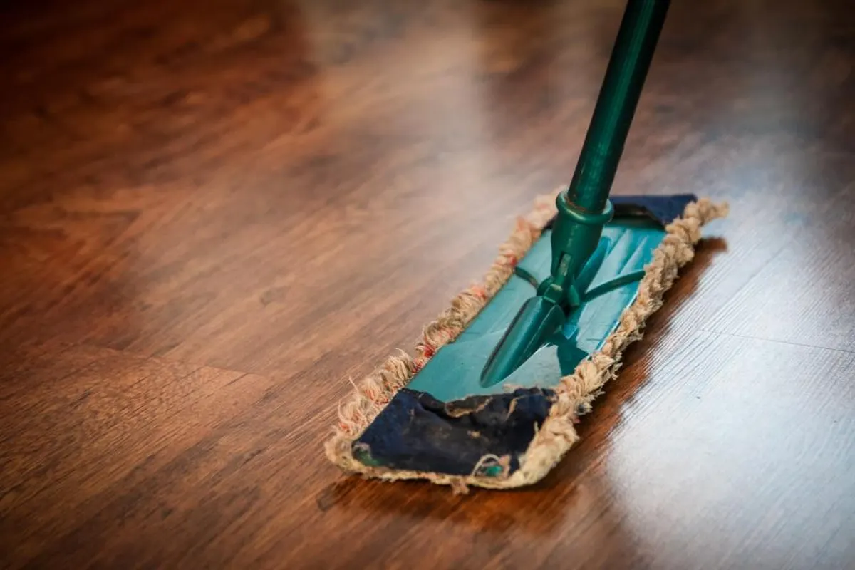 wooden floor being cleaned with a flat mop