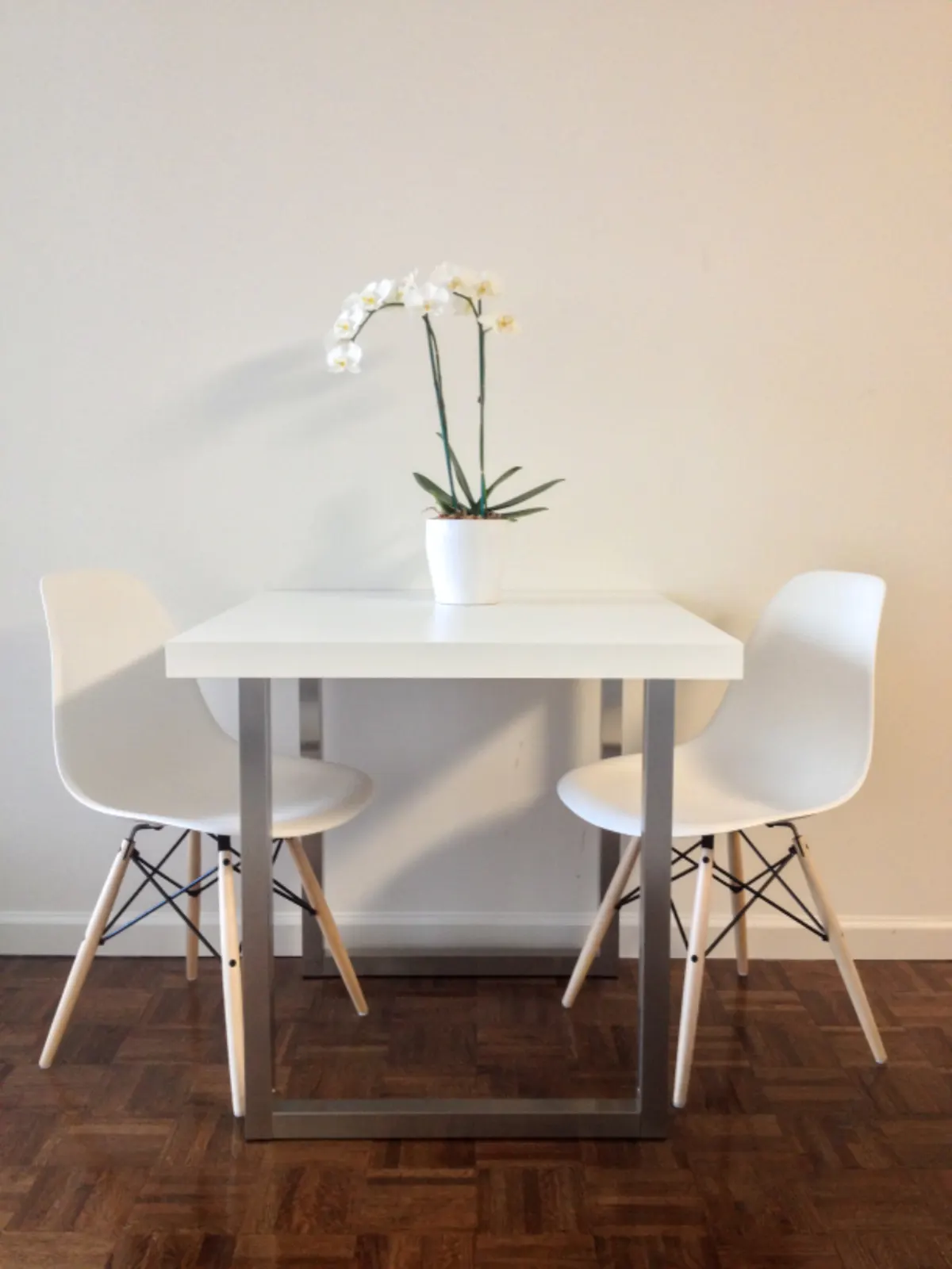 small white table and chairs by a window