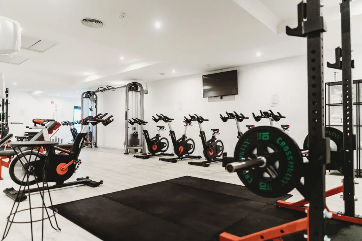 bright gym with bikes and weight racks