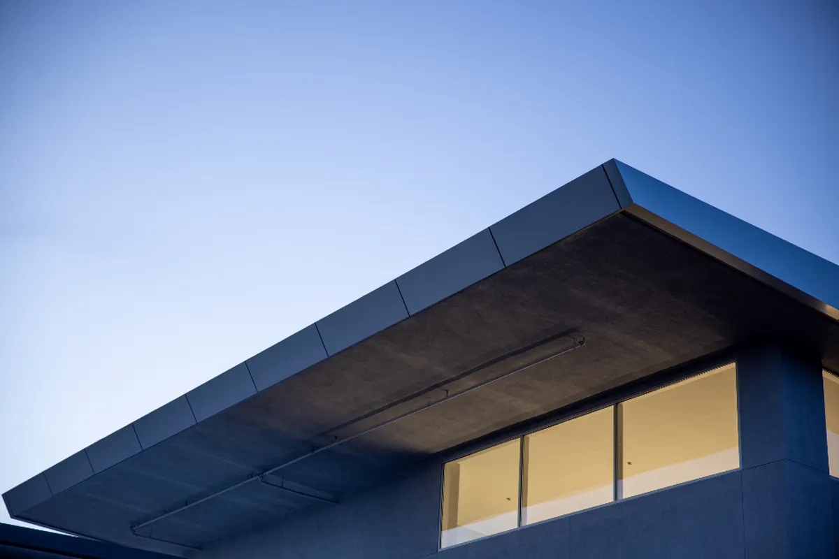 modern house with a cantilevered roof against blue sky