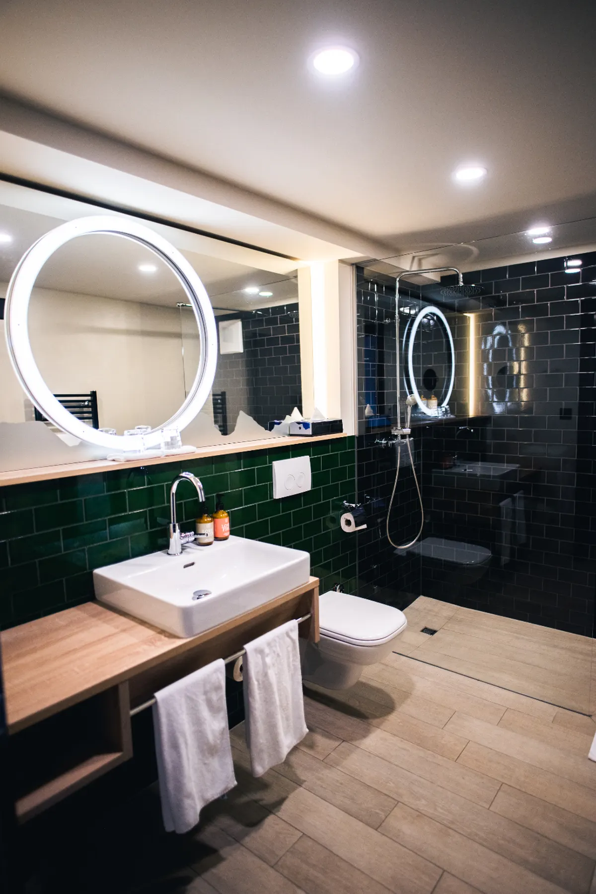 dark modern bathroom with lit mirror