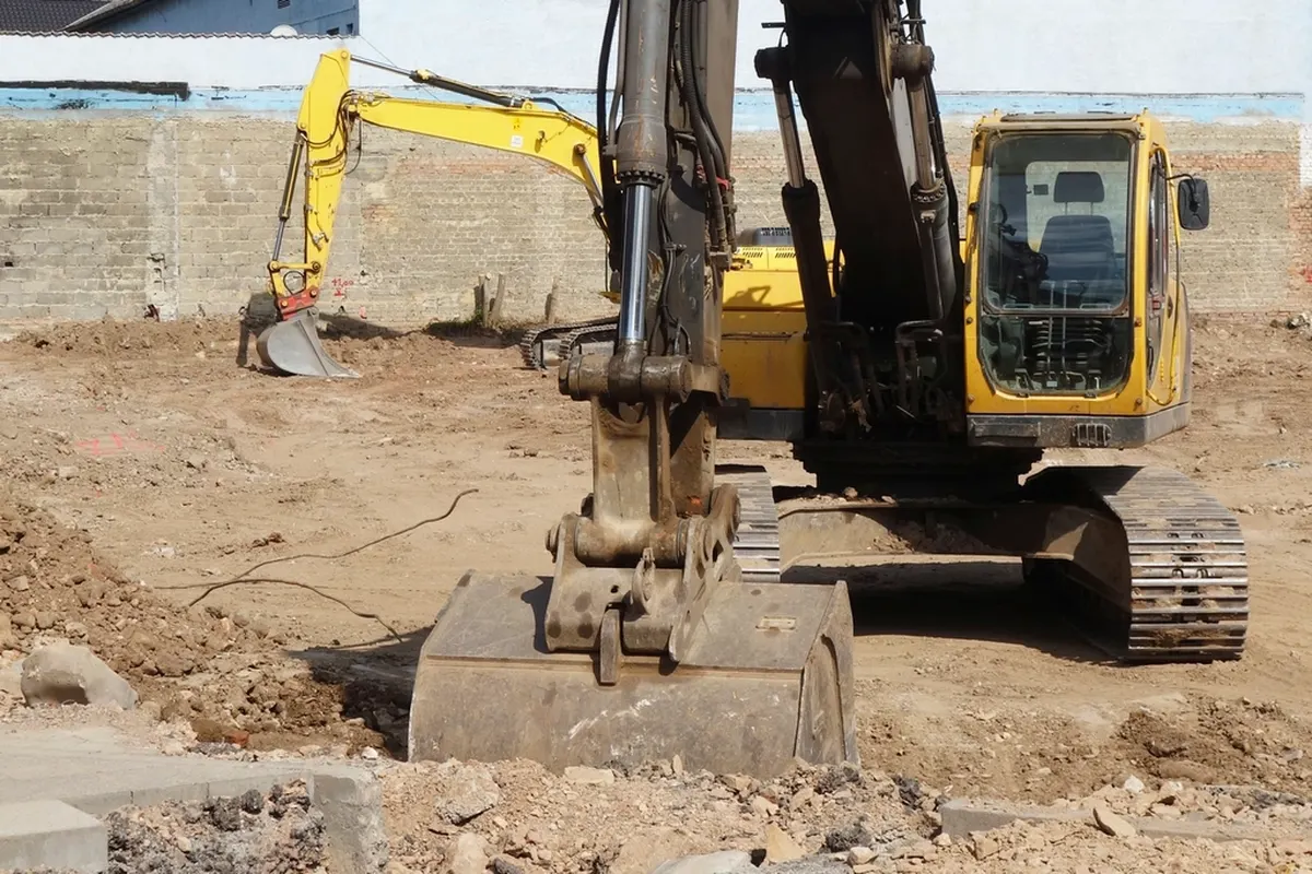 yellow excavator digging on a residential lot