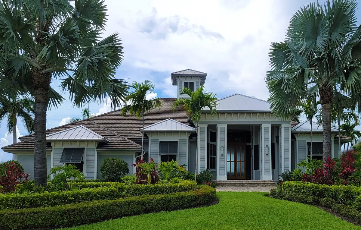 Stucco home with palm trees in a Naples neighborhood