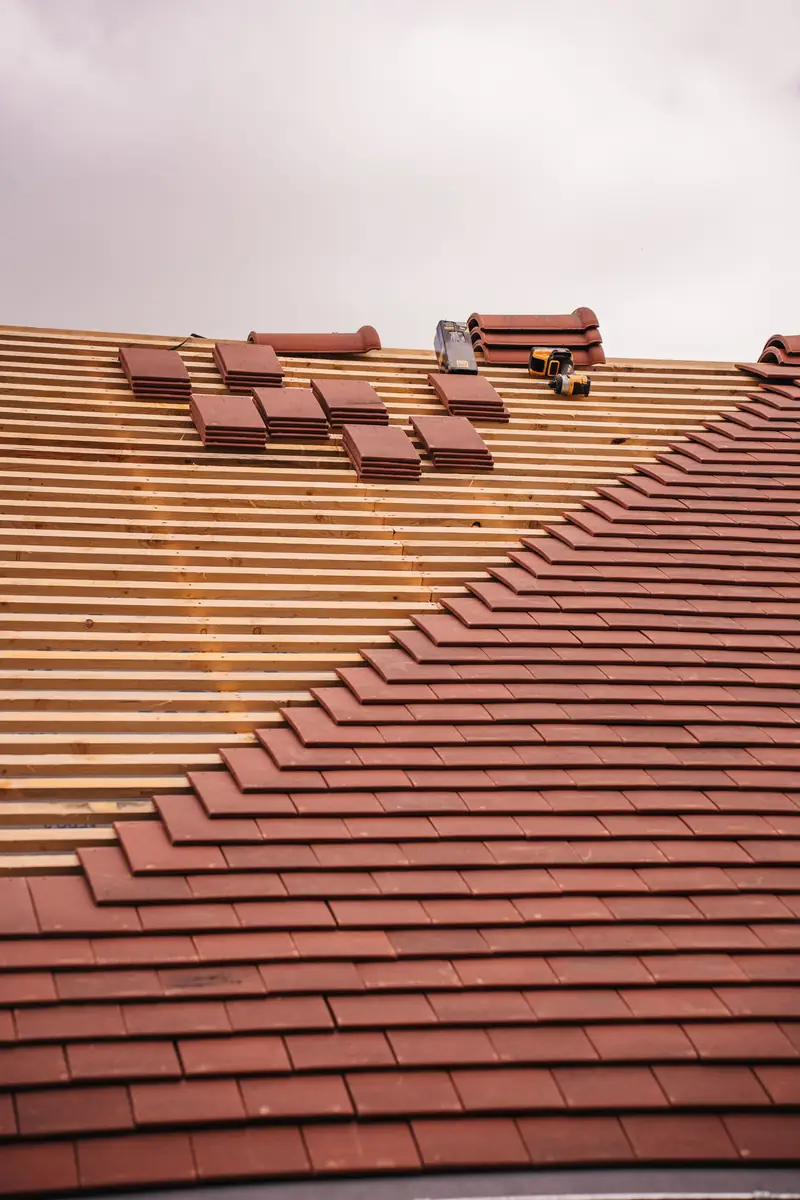 terracotta roof tiles being laid on a new roof