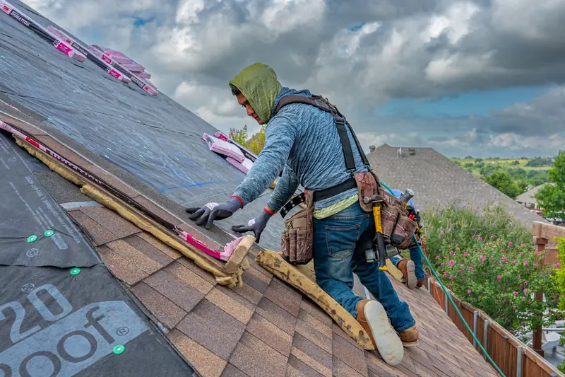 roofer installing synthetic underlayment on a pitched roof