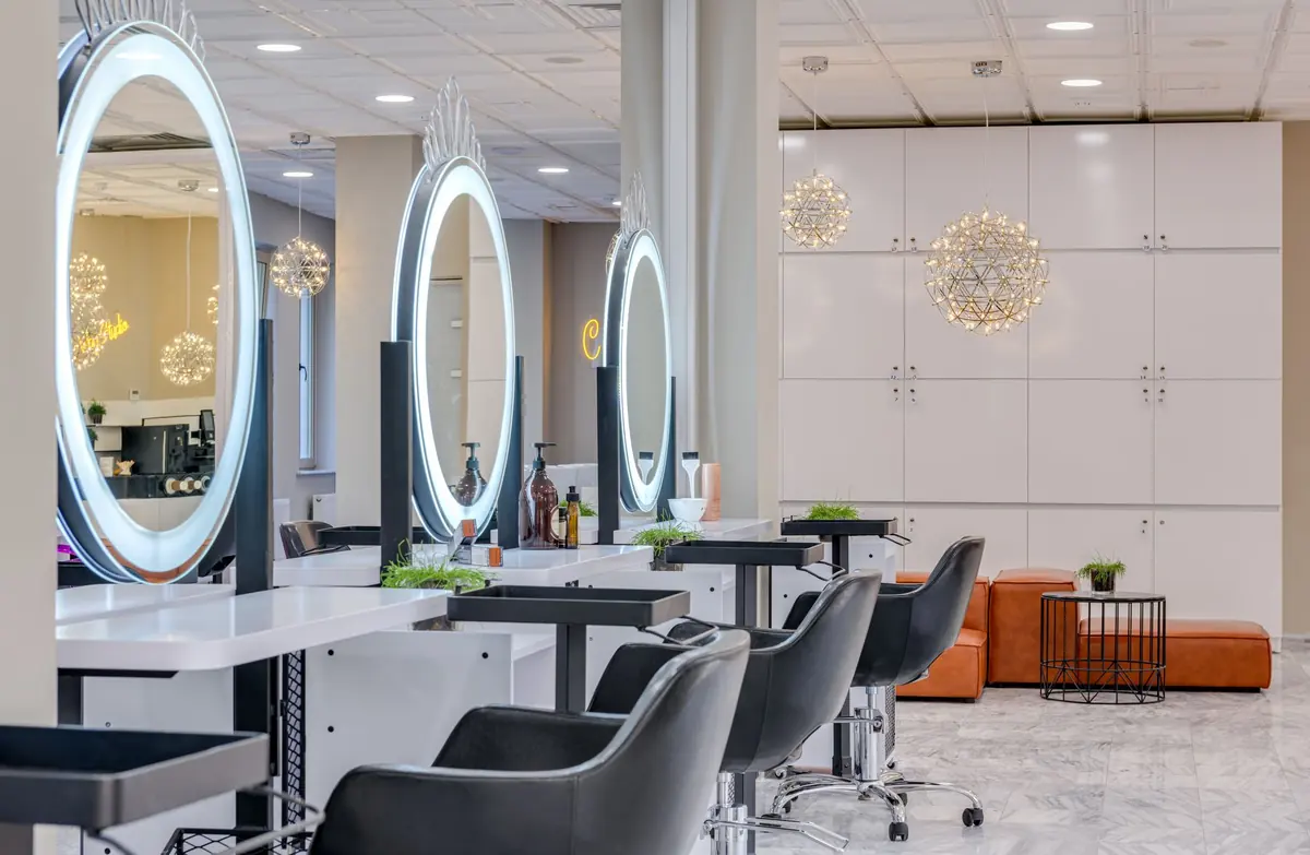 bright salon interior with round mirrors and styling stations