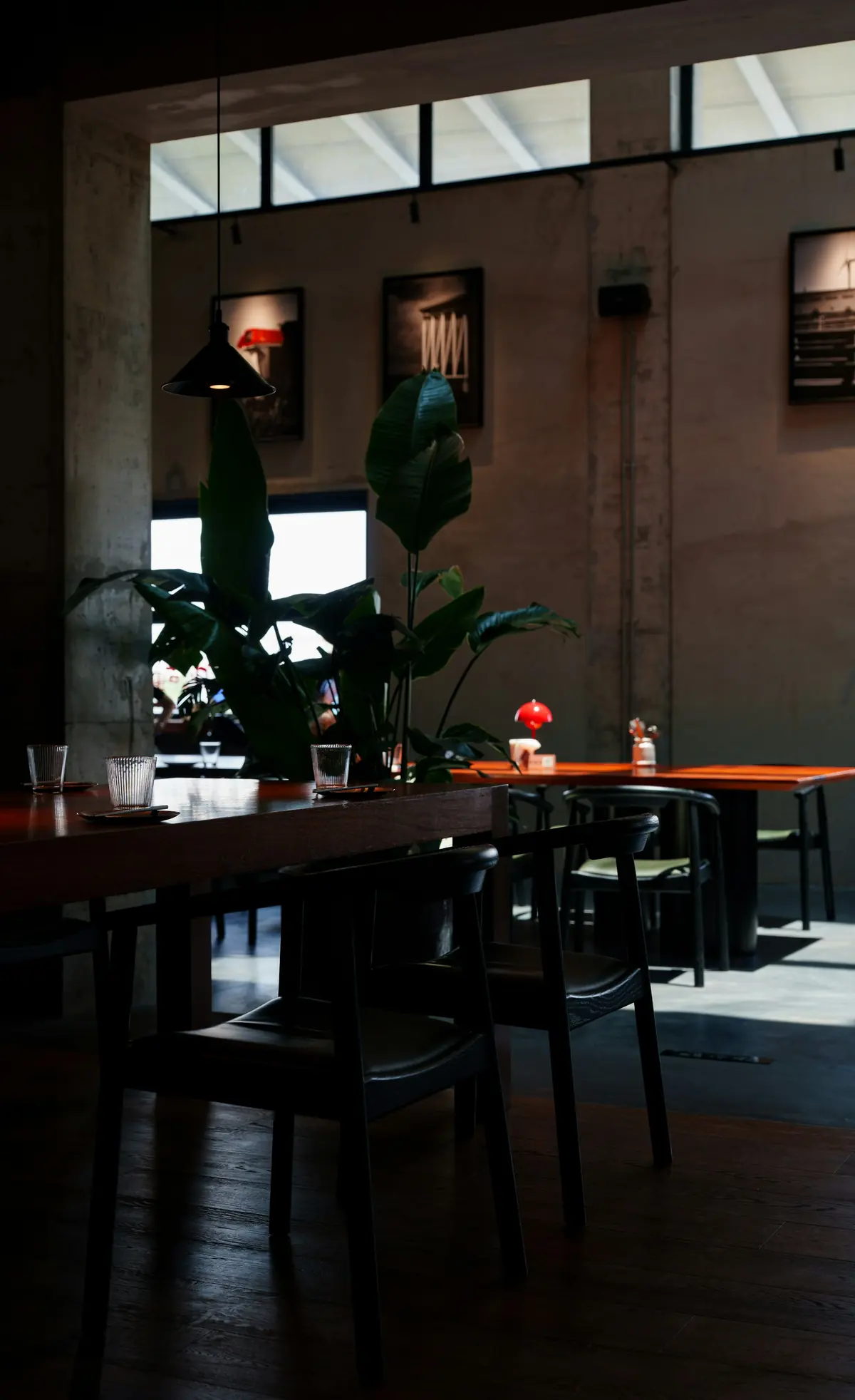 dining room with dark wood tables, pendant lights, and large windows