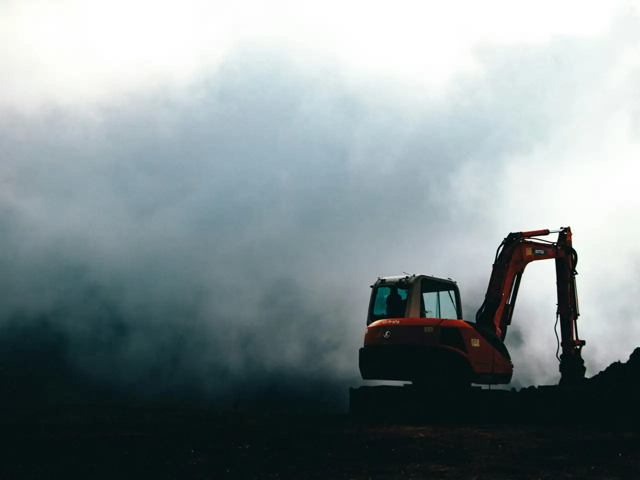 Stonecrest excavator working a job site at dawn under low fog