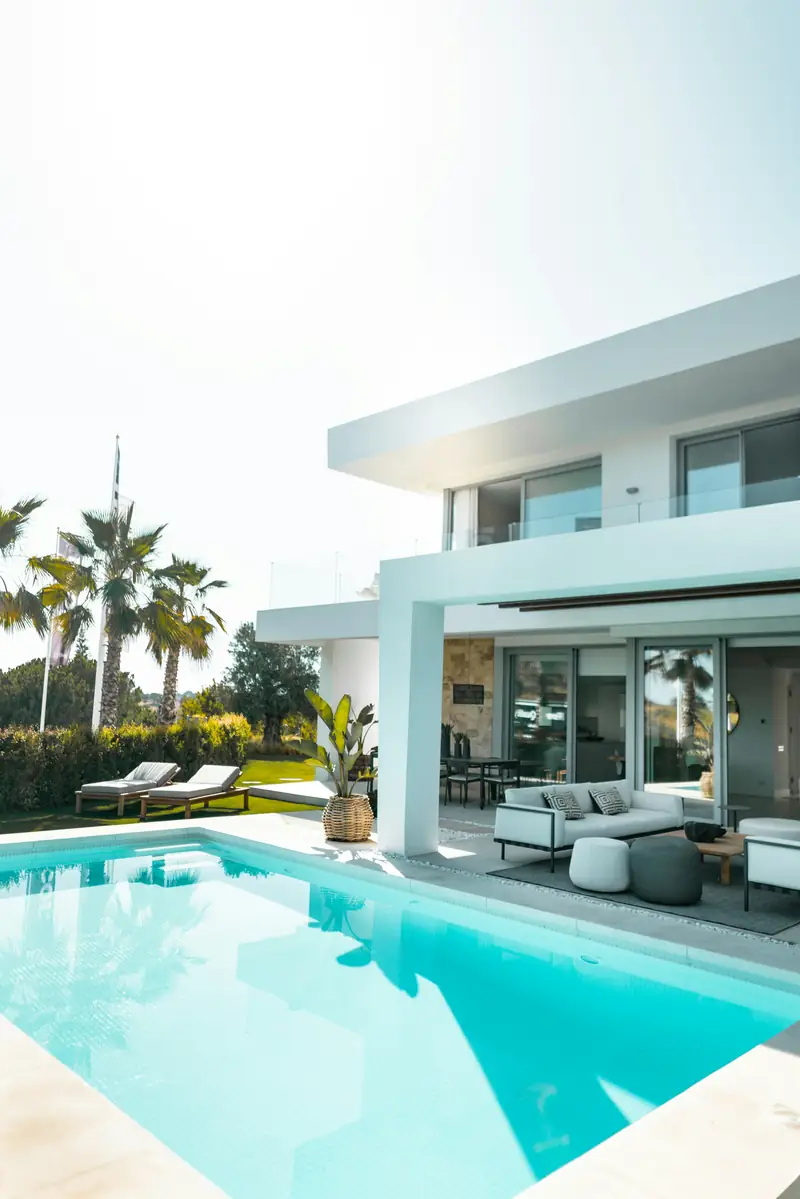Modern white villa with a turquoise pool and palms