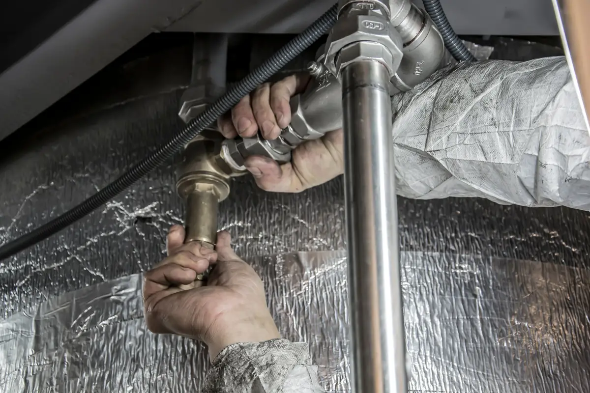 Plumber tightening a copper pipe fitting