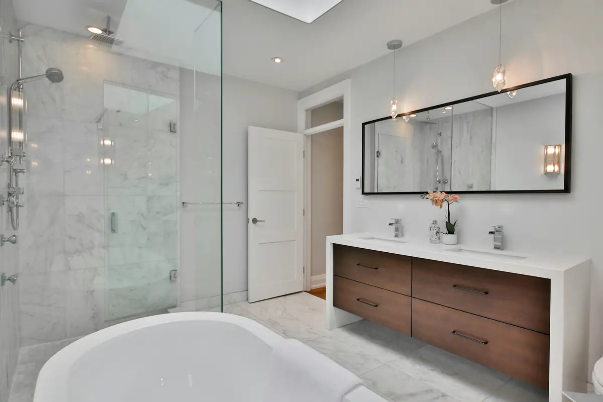 serene marble bathroom with freestanding tub and walnut vanity