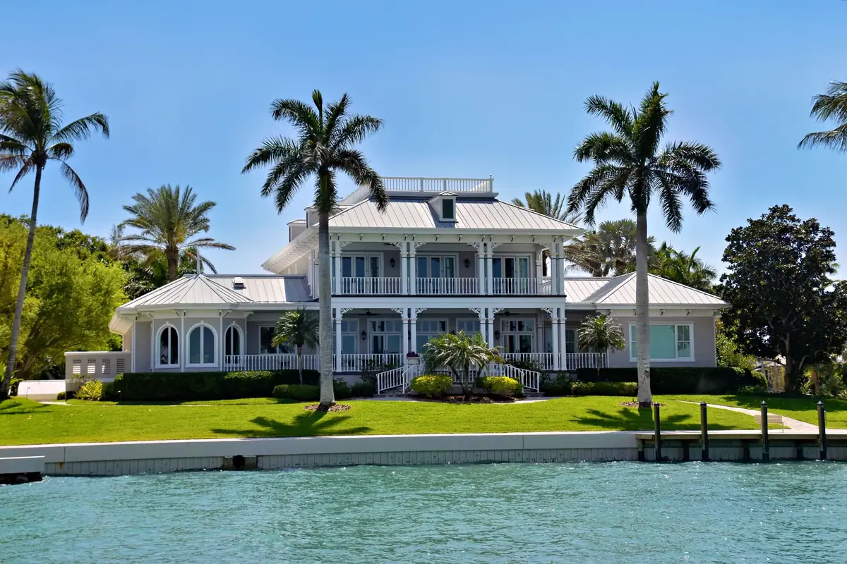 white waterfront estate with palms on a Naples canal