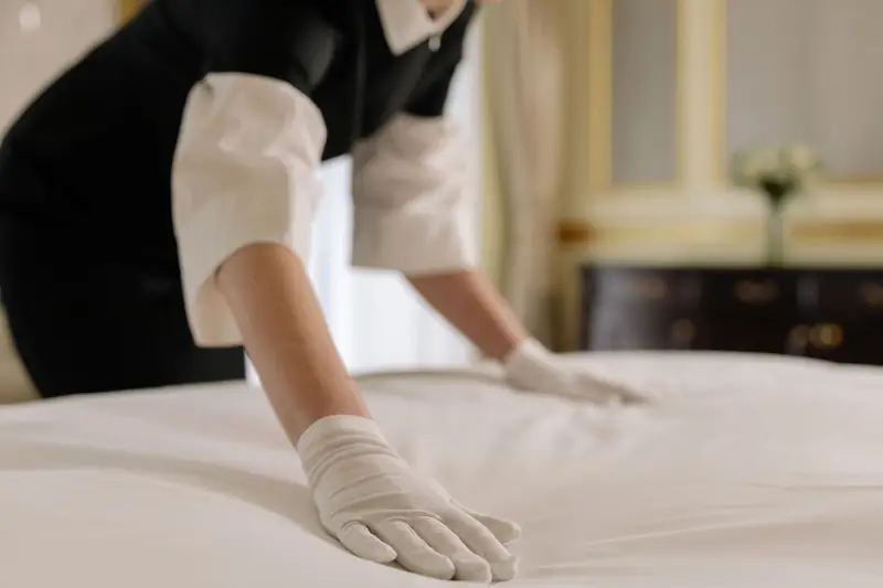 gloved hands smoothing a white pillowcase