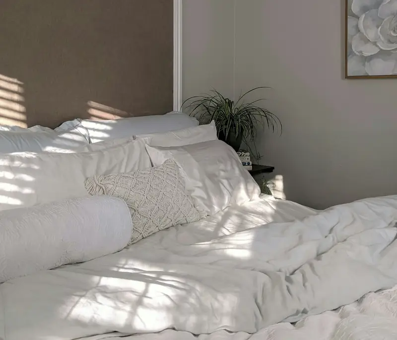 sunlit bedroom with freshly turned-down white linens