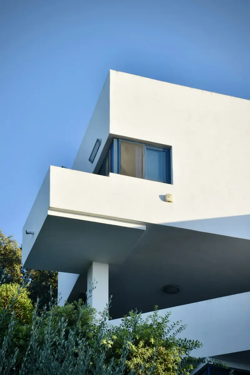 white cantilevered concrete volume against a deep blue sky
