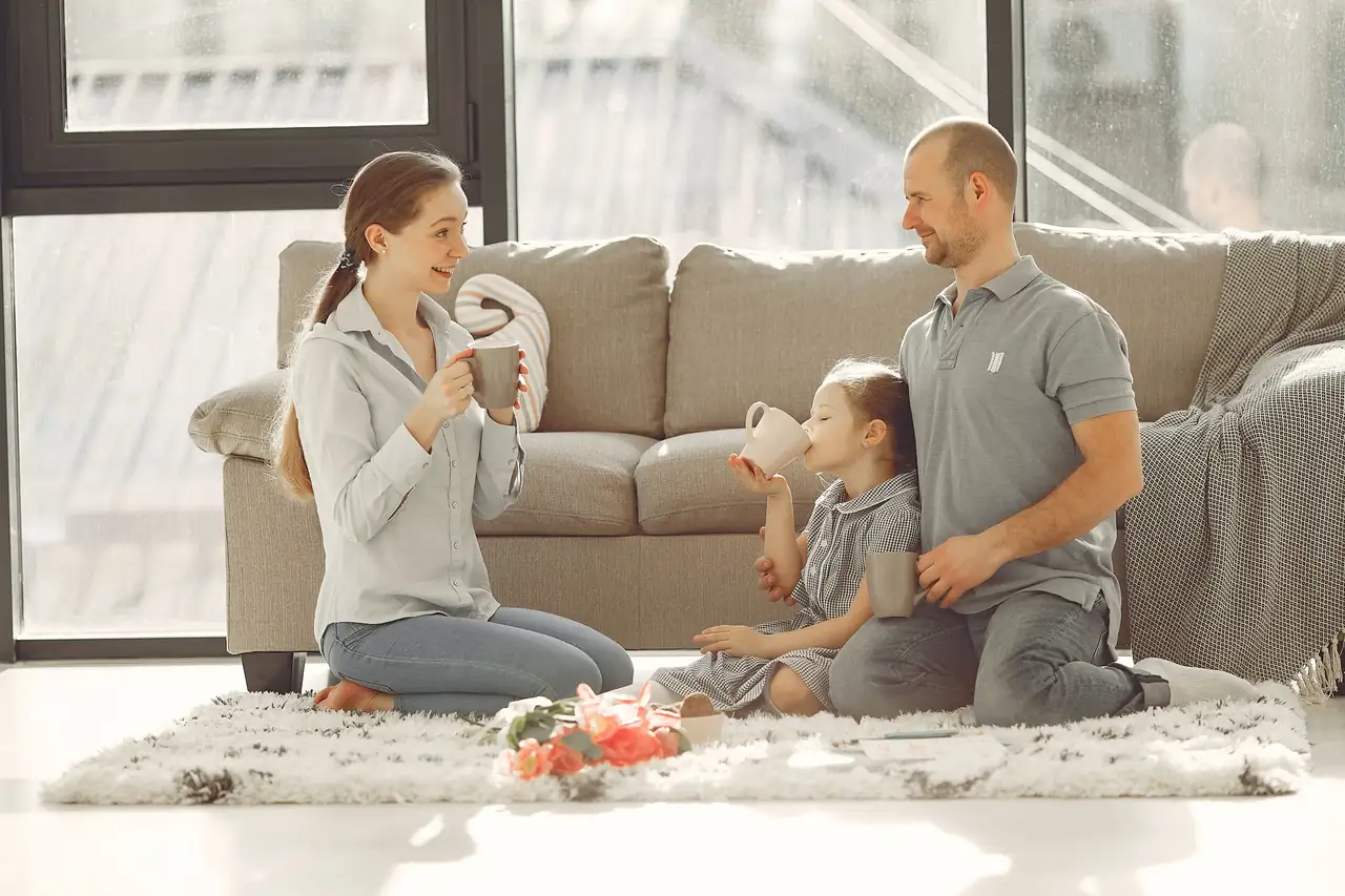 family relaxing together on the floor of a bright, cool living room